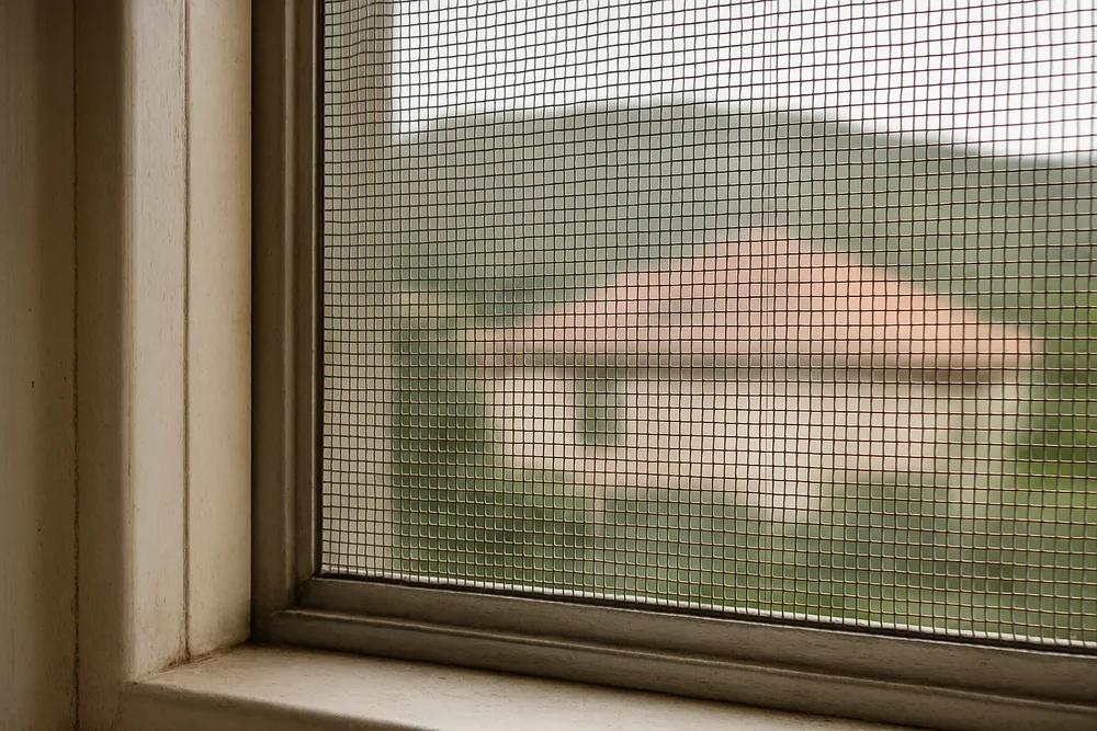 A fine metal mesh screen over an openable window — bushfire screens and mesh, Blue Mountains. Illustrative example.