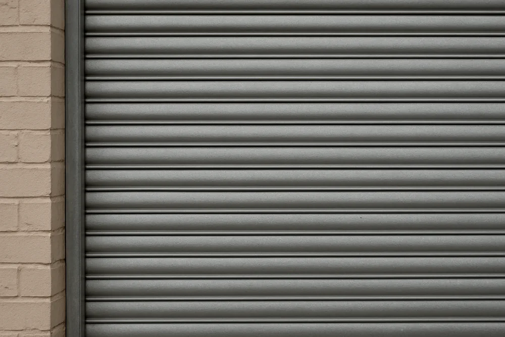 A close view of metal shutter slats running in a side channel — bushfire shutters, Blue Mountains. Illustrative example.